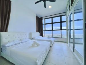 马六甲Atlantis Residences Melaka的海景卧室内的两张床