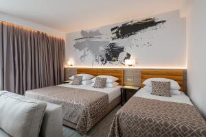 杜布罗夫尼克伊夫卡酒店的酒店客房设有两张床,墙上挂有绘画作品