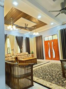 Kampung RajaTeratak Ammara Homestay Besut with private pool的客厅配有沙发和桌子