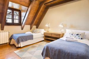 巴奎伊拉-贝莱特Luderna - Casa con terraza Cuylas的阁楼卧室设有两张床和窗户。