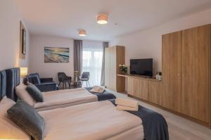 达布基Srebrna Wydma Resort的酒店客房设有两张床和一台平面电视。