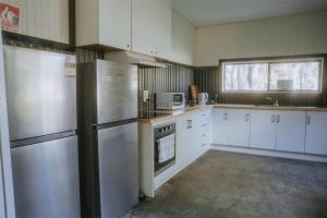 Dadswells BridgeTiny House 19 at Grampians Edge的厨房配有白色橱柜和不锈钢用具