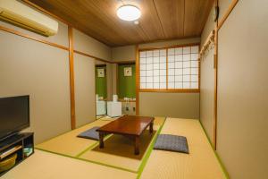 本宫Guest House Takiyoshi的客厅配有桌子和电视