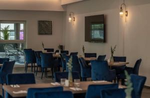 达布基Srebrna Wydma Resort的用餐室配有木桌和蓝色椅子