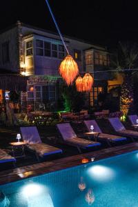 阿拉恰特多特麦维斯姆阿拉卡提酒店的游泳池在晚上提供躺椅和椅子