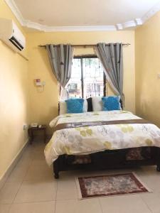 坦噶CBA Hotel的一间卧室设有一张大床和一个窗户。