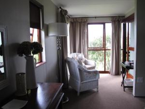 BalgowanMidlands Forest Lodge的客厅配有椅子和窗户