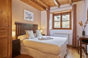 GessaLuderna - Apartamento con terraza Orri A3的一间卧室配有一张床、一张书桌和一个窗户。