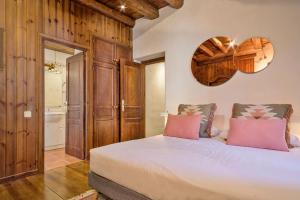 贝特伦Luderna - Casa Coto Moreu的卧室配有带粉红色枕头的大型白色床