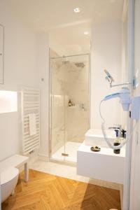 贝诺代Les Garennes - Hôtel Spa Bénodet的带淋浴和卫生间的白色浴室
