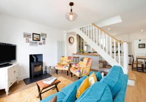 金斯韦尔Oystershell Cottage的客厅设有蓝色的沙发和楼梯。