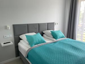 厄尔科Apartament AQUA MAZURY的床上有2个蓝色枕头