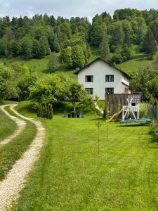 莫伊西德约斯RDT Guest House-Rai din Transilvania的草地庭院,带房子和游乐场