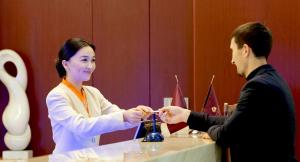 阿斯塔纳北京大厦·阳光酒店阿斯塔纳的男人把女人的饮料送在桌子上