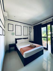 吉利特拉旺安Akalanka Homestay的一间卧室设有一张床和一个大窗户