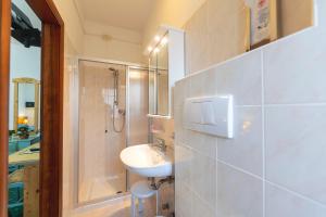 圣洛伦佐因巴纳莱Hotel Castel Mani的白色的浴室设有水槽和淋浴。