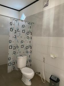 吉利特拉旺安Akalanka Homestay的一间带卫生间和淋浴帘的浴室