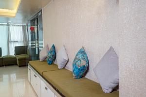 兰奇Hotel Pearl by Revgrow360的四个枕头坐在一个房间里长凳上