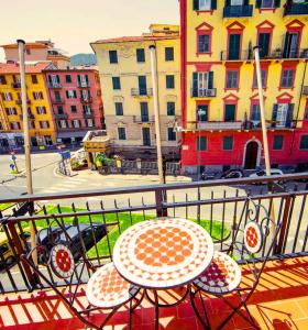 斯培西亚Hotel Venezia的阳台配有桌椅,设有建筑
