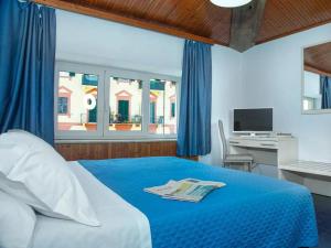 斯培西亚Hotel Venezia的一间卧室配有一张床、一张书桌和一个窗户。
