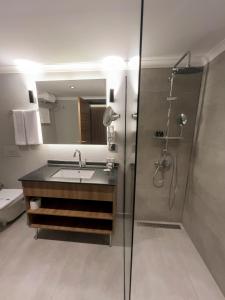 特拉布宗Sera Lake Center Hotel的一间带水槽和玻璃淋浴的浴室