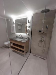 特拉布宗Sera Lake Center Hotel的浴室配有盥洗盆和带镜子的淋浴
