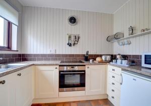 Walton WestShippon的厨房配有白色橱柜和炉灶烤箱。