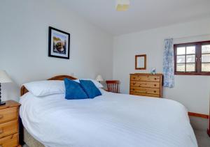 Walton WestShippon的卧室配有带蓝色枕头的大型白色床