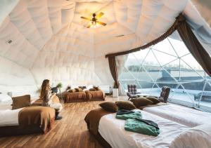 山中湖村VISION GLAMPING Resort & Spa 山中湖 ビジョングランピングリゾート山中湖的坐在四床间中的女人