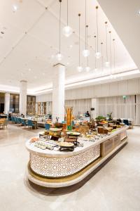勒克瑙Holiday Inn Lucknow Airport, an IHG Hotel的一个大大堂,配有桌子和食物
