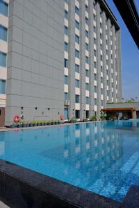 勒克瑙Holiday Inn Lucknow Airport, an IHG Hotel的大楼前的大型游泳池