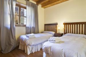 GessaLuderna - Apartamento Orri A1的一间卧室配有两张带毛巾的床