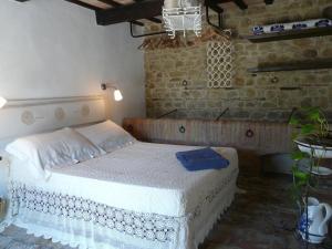 托伦蒂诺Podere Del Fagiano的一间砖墙内白色床的卧室