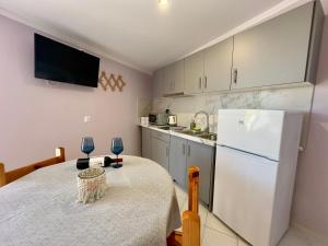 波罗斯安妮莫斯公寓式酒店的厨房配有桌子和白色冰箱。
