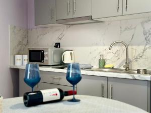 波罗斯安妮莫斯公寓式酒店的厨房配有一张桌子,上面放有两杯葡萄酒