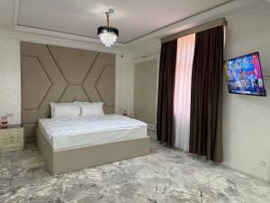 撒马尔罕Ko'k Saroy Plaza Hotel的一间卧室设有一张大床和一个窗户。