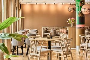 斯塔万格佛勒斯时尚酒店的一间设有桌椅的餐厅,种植了植物