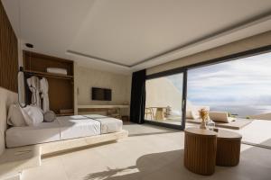 费拉Pnoe Luxury Suites的一间卧室设有一张床和一个大窗户