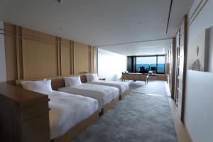热海Pearl Star Hotel ATAMI的酒店客房设有两张床和窗户。