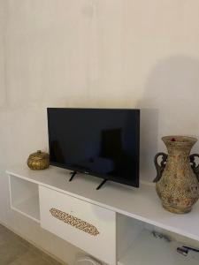 米多恩Djerba rêve vacances Zohra的白色架子上的平面电视