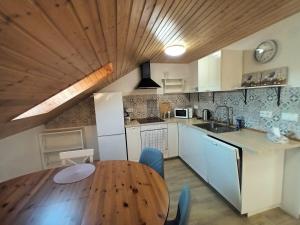 Apartmán Svaté Pole的厨房设有木桌和木制天花板。