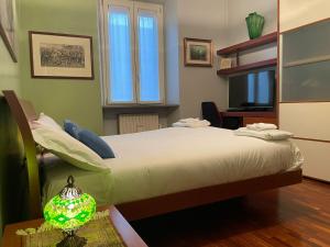 米兰Cozy flat mins walk to Navigli and metro Porta Genova的一间卧室配有一张床、一张书桌和一台电视
