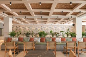 赫索尼索斯Sergios Hotel的大堂设有长长长长凳,配有椅子和植物