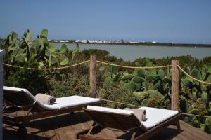 拉萨维纳Cas Saliners - Villa Can Paya的一个带2把躺椅的甲板,享有水景