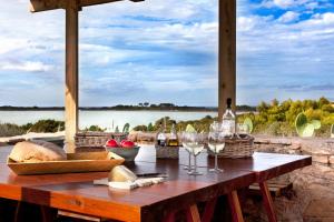 拉萨维纳Cas Saliners - Villa Can Paya的配有酒杯的野餐桌,享有水景