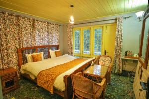 帕哈尔加姆Hotel Little Silver的卧室配有床、桌子和窗户。