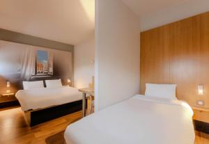 阿拉斯B&B HOTEL Arras的酒店客房配有两张床和一张书桌