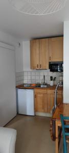 卡布尔Cabourg Plage的厨房配有白色家电和木制橱柜