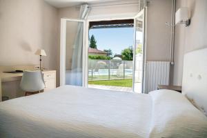 Séreilhacle Relais des Tuileries的一间卧室设有一张床和一个滑动玻璃门