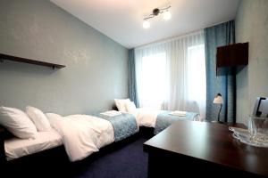 MońkiZajazd Monki的酒店客房配有两张床和一张书桌